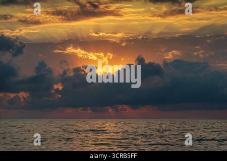 Aufnahme des dramatischen Sonnenuntergangs am Strand Stockfoto