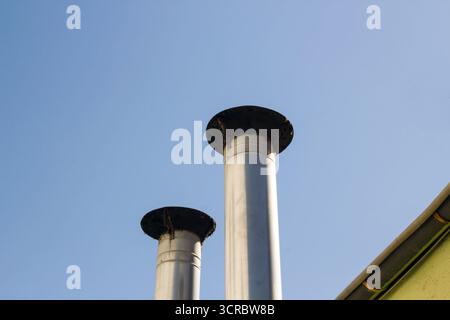 Der Küchen-Lüftungsschornstein aus Metall auf dem Dach des Gebäudes, ungefiltert und sehr schmutzig Stockfoto