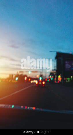 Stadtfahrt zur blauen Stunde auf der Hauptstraße im Stadtfluss, verschwommenes Bokeh, vertikal Stockfoto