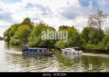 Worcester, Worcestershire, England, Großbritannien - 24. August 2025: Schmales Boot und ein Motorboot, das sich auf dem Fluss Severn überquert Stockfoto