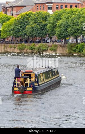 Worcester, Worcestershire, England, Großbritannien - 24. August 2025: Schmalboot segelt auf dem Fluss Severn, der an der Stadt Worcester vorbeifließt. Stockfoto