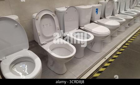 Russland, Moskau - 15. August 2025. Verschiedene moderne weiße Keramik-Toiletten in einem Verkaufsraum Stockfoto