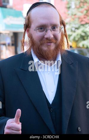 Ein Foto von Kopf und Schultern eines fröhlichen chassidischen Juden mit roten Haaren und Peyus. In Brooklyn, New York. Stockfoto