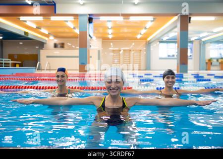 Schwimmerinnen üben synchronisierte Bewegungen im Pool Stockfoto