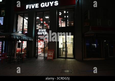 Eine Filiale der US-amerikanischen Schnellrestaurantkette Five Guys, Aussenaufnahme bei Nacht. *** Ein Zweig der US-Fastfood-Kette fünf Typen, Außenaufnahme nachts Stockfoto