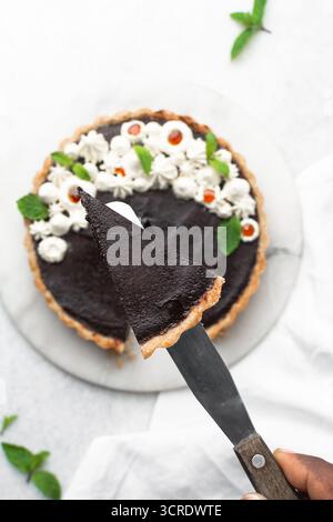 Blick von oben auf ein Stück Schokoladentorte auf einer weißen Platte, Blick von oben auf keine Schokoladentorte auf weißem Hintergrund, ein Stück Schokoladentorte Stockfoto