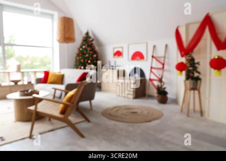 Verschwommener Blick auf das Wohnzimmer mit Sofa, Tannen und Einrichtung für japanische Neujahrsfeiern Stockfoto