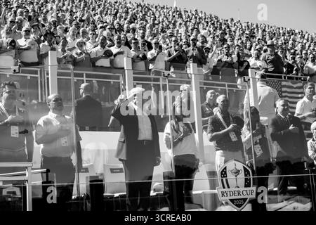 Präsident Donald J. Trump grüßt während der Nationalhymne am Eröffnungstag des Ryder Cup 2025 auf dem Bethpage Black Golf Course in Farmingdale, New York, zusammen mit seiner Enkelin Kai Madison Trump. September 2025. Bild mit freundlicher Genehmigung des Weißen Hauses. Stockfoto
