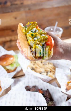 Ein Blick auf eine Hand, die einen Chicago Hot Dog hält. Stockfoto