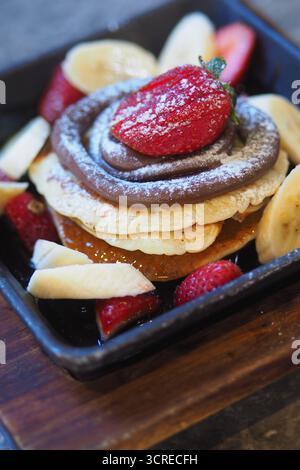 Ein Stapel Pfannkuchen mit Schokoladencreme und Erdbeeren Stockfoto