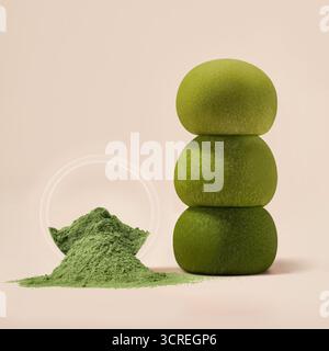 Stapel grüner Matcha-Dessertbällchen mit Matcha-Pulver, Matcha-Pulver in einer Glasschale und drei grünen Steinen auf hellem Hintergrund Stockfoto