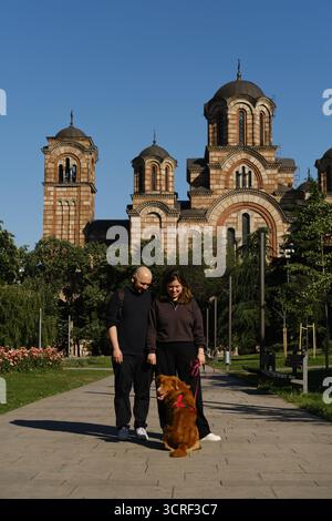 Paare stehen mit Nova Scotia Duck Tolling Retriever vor der Markuskirche in Belgrad. Reisen mit Hund Konzept. Stockfoto