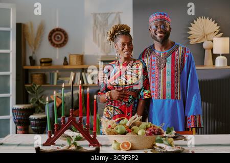 Porträt eines Schwarzen Paares mittleren Alters, das Kwanzaa mit Kinara Kerze feiert Stockfoto