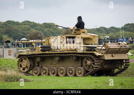 Der laufende Panzer III, der während der Ausstellung in der Arena zu sehen war. Der Tiger Day des Tank Museum ist eine halbjährliche Veranstaltung im Bovington Camp, bei der der Deutsche Tiger 131, der einzige einsatzfähige Tiger I Panzer der Welt, gezeigt wird. Außerdem sind weitere Panzer aus dem Zweiten Weltkrieg wie M4A2E8 Sherman „Fury“, M3 Grant und der britische Churchill Panzer zu sehen. Das Ereignis beinhaltete eine Nachstellung der Schlacht von „Gefangennahme des Tigers“, die demonstrierte, wie der Tiger 131 am 24. April 1943 in Tunesien vom 42. Bataillon Royal Armored Corps und 2. Sherwood Foresters gefangen genommen wurde. Stockfoto