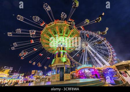 Volksfestzeit in Stuttgart. Riesenrad und Kettenkarussell am Abend. Das 178. Cannstatter Volksfest auf dem Wasen ist eines der bedeutendsten Stockfoto