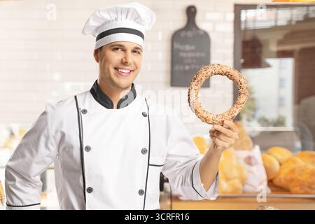 Ein Bäcker, der in einer Bäckerei einen Simit hält Stockfoto