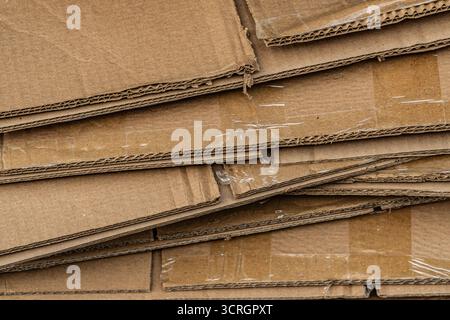 Eine Ansicht von oben nach unten auf einen großen, unordentlichen Stapel flacher Wellpappkartons, die für das Recycling bereit sind. Stockfoto