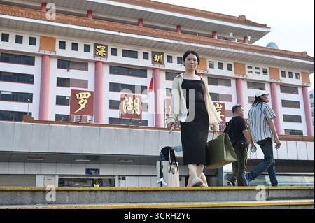 Menschen, die am 1. Oktober 2025 in Shenzhen, China, am Hafen von Luohu vorbeilaufen. Heute ist der Nationaltag der Volksrepublik China. (Foto von Kobe Li/Nexpher Images) Stockfoto