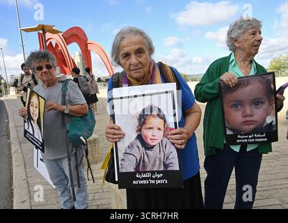Yad Vashem Holocaust Museum, Israel. Oktober 2025. Veronica Cohen, 81 (C), hat ein Foto eines palästinensischen Mädchens, das während einer stillen Mahnwache in der Nähe des Yad Vashem Holocaust Museums in Gaza getötet wurde, um gegen die Tötung und Kriegsverbrechen zu protestieren, die Israel in Gaza begangen hat, am Mittwoch, dem Vorabend von Jom Kippur, dem Tag der Versöhnung, 1. Oktober 2025. Die Mahnwache markierte einen Moment des Gedenkens und der moralischen Reflexion und verband die Erinnerung an vergangene Gräueltaten mit einem dringenden Aufruf, den Verlust unschuldiger Menschenleben heute im Krieg zwischen Israel und der Hamas zu beenden. Jom Kippur ist der heiligste Tag im jüdischen Kalender. Cred Stockfoto