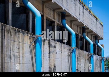 Das blaue Rohr ist an einem Kühlturm befestigt und von außen sichtbar. Stockfoto