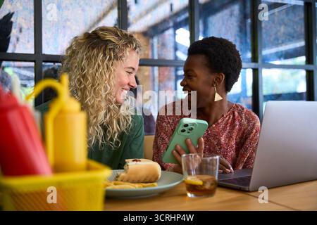 Verschiedene Freunde lachen und genießen gemeinsam ein Mittagessen Stockfoto