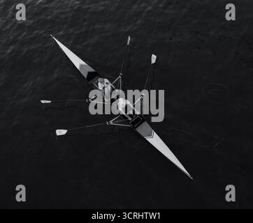 Luftaufnahme von zwei Rudern in Racing Boat on Calm Water, Teamwork und Precision in Motion, aufgenommen in minimalistischem Schwarz-weiß Stockfoto