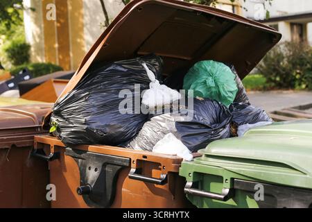 Müllcontainer voll Müllbeutel. Details zur Abfallentsorgung im Außenbereich. Umweltproblem mit Müllüberlauf. Stadtverschmutzung mit Plastik. Stockfoto