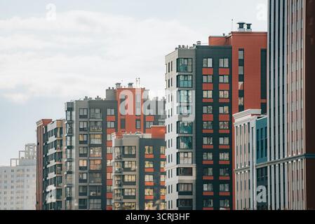 Neue Hochhäuser mit moderner Architektur und vielfältigen Materialien spiegeln urbanes Leben, Entwicklung und die Erweiterung der Skyline der Stadt unter hellem Himmel wider Stockfoto