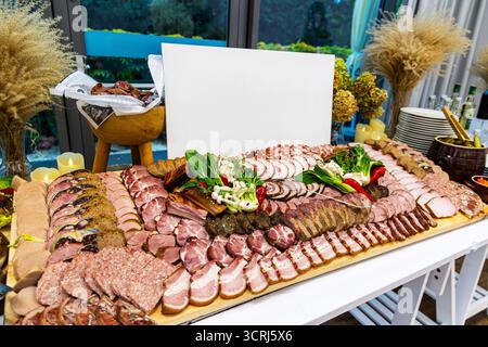 Traditionelle Wurstplatte mit verschiedenen Wurstwaren. Große rustikale Wurstplatte mit einer großen Auswahl an geschnittenem Wurstaufschnitt und Würstchen Stockfoto