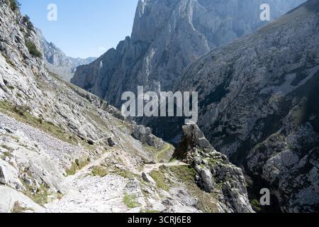 Eine zerklüftete Berglandschaft mit felsigen Klippen und einem schmalen Pfad von der Ruta del Cares Wanderung im Nationalpark Picos de Europa, Spanien Stockfoto