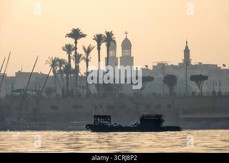 Müllsammelkähne auf dem Nil in Luxor sammeln von Kreuzfahrtschiffen vor der Michael Angel Church Stockfoto