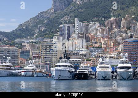 Monte Carlo, Monaco - Blick auf Monaco mit dem Port Herkules und seinen vielen Luxusyachten und vielen modernen Gebäuden im Hintergrund. Stockfoto