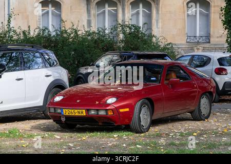 Nancy, Frankreich - Blick auf einen burgunderroten Porsche 928 S auf einem Parkplatz. Stockfoto