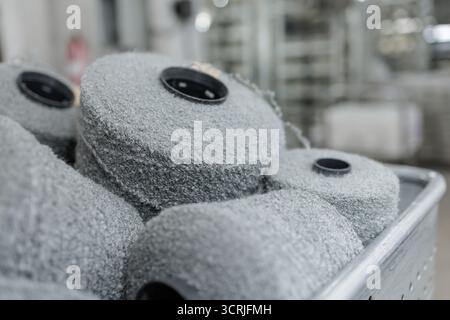 Boucle-Garnkonen in einer Textilwerkstatt, die für die Webherstellung und Stoffproduktion bereit sind, zeigen texturierte Fasern für Modepolster und Industrie Stockfoto