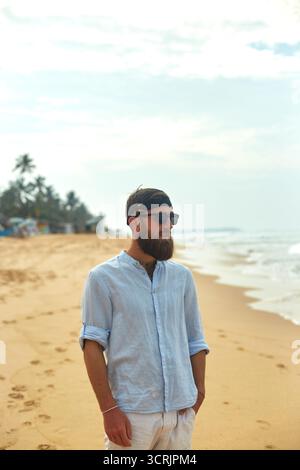 Porträt eines gutaussehenden bärtigen Mannes in Hemd am Strand. Stockfoto