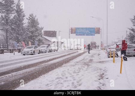 Geschäftige Hauptstraße in Bariloche, bedeckt mit frischem Schnee, Wintertourismus und urbanem Leben Stockfoto