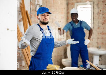 Vorarbeiter unzufrieden mit der Qualität der Reparaturarbeiten des männlichen Bauherrn Stockfoto