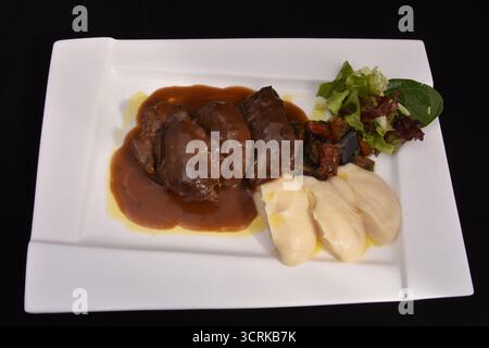 Eine Portion Leber mit Sauce, serviert mit einem cremigen Püree und einem grünen Salat. Leber ist eine nährstoffreiche Nahrung und eine wichtige Quelle für Eisen und Vitamin Stockfoto