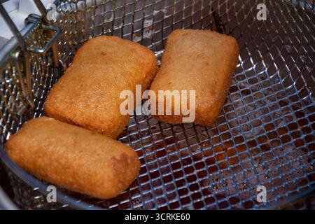 Mozzarella-Sticks werden frittiert. Mozzarella-Sticks sind eine beliebte Vorspeise oder ein Snack, der aus zerbrochenem oder paniertem Mozzarella-Käse hergestellt wird Stockfoto
