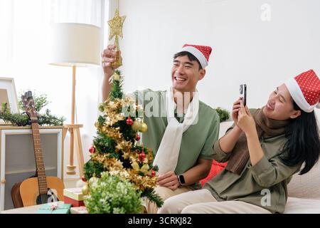 Glückliches Paar, liebevolles Paar, feiert Winterferien, weihnachtsstimmung zu Hause, dekoriert weihnachten Stockfoto