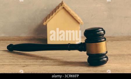 Gavel und Miniatur Holzhaus für Immobilienrecht, Immobilienauktion und Wohnungsgericht Stockfoto