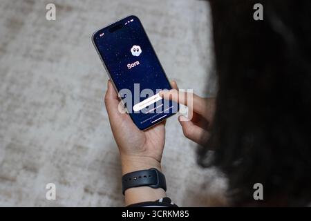 Ein iPhone-Benutzer öffnet die neue Sora-App, die von OpenAI auf der Grundlage des neuesten Videogenerationsmodells Sora 2 gestartet wurde. Stockfoto