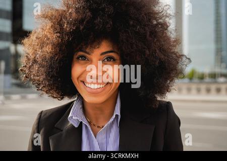 Afro Latina Geschäftsfrau Lächeln vor Bürogebäuden - professionelles Firmenporträt Konzept Stockfoto