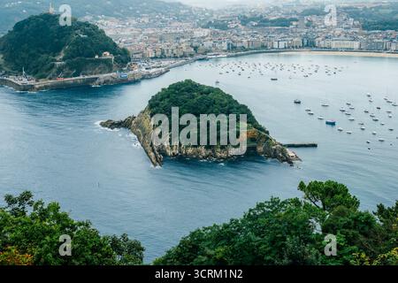 La Concha Bay mit Santa Clara Island ab Mount Igueldo, San Sebastian, Baskenland, Spanien. Ikonischer Blick Auf Die Küste, Urban Beach, Segelboote, Atlantik Stockfoto