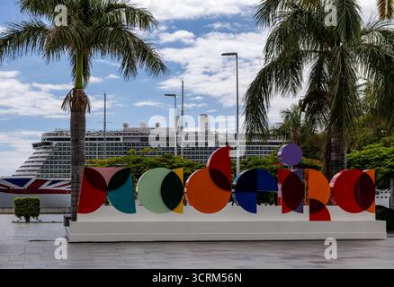 Farbenfrohes Madeira-Schild in Funchal mit einem Kreuzfahrtschiff im Hintergrund, umgeben von Palmen an einem hellen Tag Stockfoto