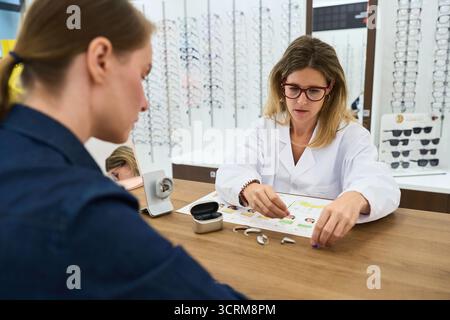 Audiologe hilft Patienten bei der Wahl eines Hörgerätes Stockfoto