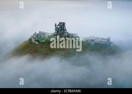 Corfe Castle, Dorset, Großbritannien. Oktober 2025. Wetter in Großbritannien: Aus der Vogelperspektive auf Corfe Castle in Dorset, während ein Nebel die Burgruinen bei Sonnenaufgang umgibt. Bildnachweis: Graham Hunt/Alamy Live News Stockfoto