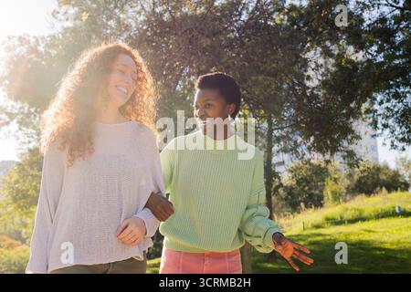Zwei junge Frauen, die während eines Spaziergangs lächeln und reden Stockfoto