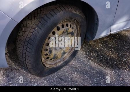 Nahaufnahme eines Platten Reifens an einem geparkten Auto. Stockfoto