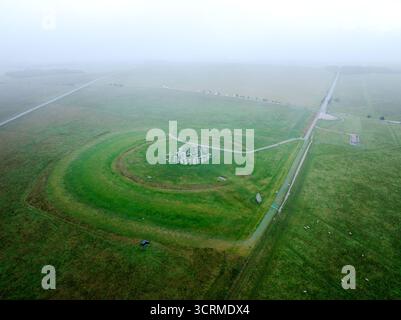 Aus der Vogelperspektive von Stonehenge, einem prähistorischen Monument inmitten einer nebeligen, grünen Landschaft, dessen alte Steine in starkem Kontrast zum weichen, diffusen Licht stehen, Salisbury, England, Vereinigtes Königreich. Stockfoto